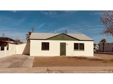 Charming single-story home featuring a white facade, symmetrical windows, and a secure front door at 2502 W Jefferson St, Phoenix, AZ 85009