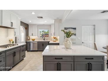 Bright kitchen features gray and white cabinetry, stainless steel appliances, and a large center island with white countertops at 3221 N 41St Pl, Phoenix, AZ 85018