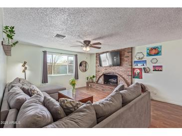 Cozy living room with brick fireplace, modern furniture, and natural light from a window at 3607 N 21St Ave, Phoenix, AZ 85015