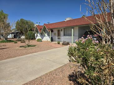Charming single-story home with a red tile roof and an attractive low maintenance desert landscape at 3932 W Lawrence Ln, Phoenix, AZ 85051