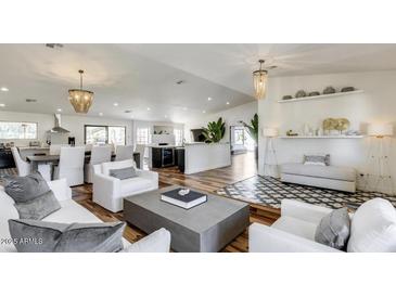 Open-concept living space with stylish decor, hardwood floors, and seamless flow to kitchen and dining areas at 6527 W Bloomfield Rd, Glendale, AZ 85304