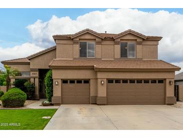 Lovely two-story home featuring a three-car garage and desert landscaping at 6963 W Aurora Dr, Glendale, AZ 85308