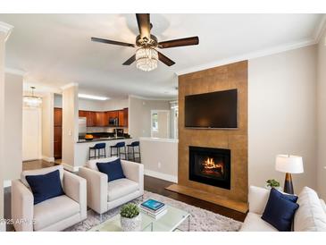 Cozy living room featuring a fireplace and open-concept kitchen, perfect for entertaining guests at 7009 E Acoma Dr # 2134, Scottsdale, AZ 85254