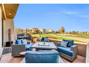 Relaxing patio area with comfortable seating, a fire pit, and picturesque golf course views at 7400 E Gainey Club Dr # 123, Scottsdale, AZ 85258