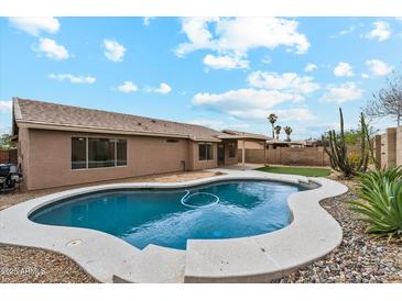 Inviting backyard pool with desert landscaping and blue skies at 9306 E Fairbrook St, Mesa, AZ 85207