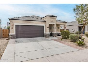 Charming single-story home featuring a two-car garage, desert landscaping, and a welcoming front porch at 1189 E Tyler Ln, Casa Grande, AZ 85122