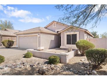 Single story home with desert landscaping, light stucco, tiled roof and two car garage at 1559 E Peregrine Trl, Casa Grande, AZ 85122