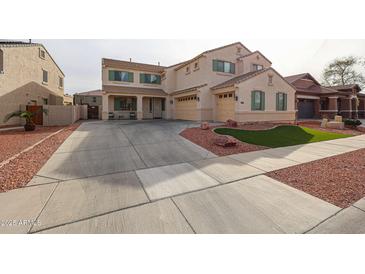 Charming two-story home featuring a spacious driveway, three-car garage, and low-maintenance landscaping with decorative rocks and turf at 17687 W Surrey Dr, Surprise, AZ 85388