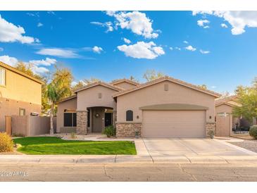 Charming single-story home featuring a two-car garage, low maintenance front yard, and tasteful stone accents at 835 E Virgo Pl, Chandler, AZ 85249
