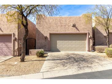 Charming home with a beige garage door, a front yard with desert landscaping and sunny skies above at 9716 N 3Rd Dr, Phoenix, AZ 85021
