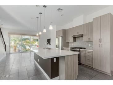 Modern kitchen with a large island, stainless steel appliances, and gray cabinets at 1717 E Morten Ave # 7, Phoenix, AZ 85020