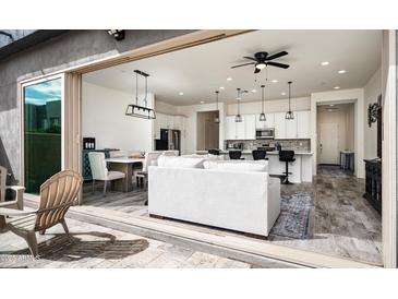 Open-concept living area features modern design, tile floors, and seamless indoor-outdoor flow at 1953 W Kinfield Trl, Phoenix, AZ 85085