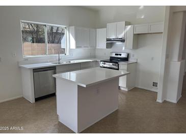 Bright kitchen with white cabinetry, stainless steel appliances and a center island, perfect for Gathering meals and entertaining at 21443 N 29Th Dr, Phoenix, AZ 85027