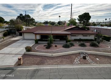 Charming single-story home with a well-maintained front yard and a spacious driveway at 5241 N Woodmere Fairway --, Scottsdale, AZ 85250