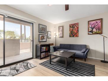 Bright living room features a sliding glass door to a balcony and stylish decor at 715 S Extension Rd # 70, Mesa, AZ 85210
