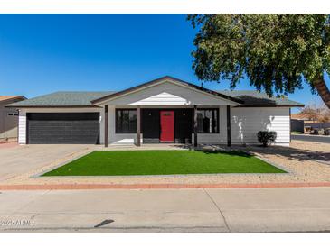 Charming single-story home featuring a well-manicured front yard and a striking red front door at 8602 W Clarendon Ave, Phoenix, AZ 85037