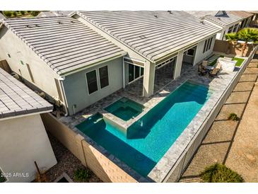 Aerial view of a backyard featuring a sparkling pool and spa, lounge area, and patio at 11203 N Northfield St, Surprise, AZ 85388