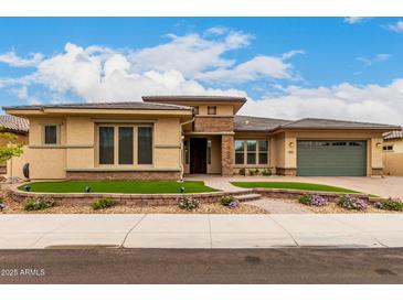 Charming single-story home with a manicured lawn, flower bed, and a two-car garage at 15936 W Bonitos Dr, Goodyear, AZ 85395