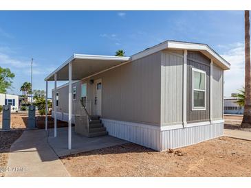 Charming home featuring a covered porch, gray siding, and landscaped surroundings on a sunny day at 2650 W Union Hills Dr # 91, Phoenix, AZ 85027