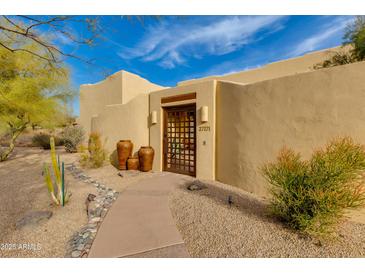 Inviting front entrance featuring a wrought iron gate, desert landscaping, and a paved walkway at 27171 N 73Rd St, Scottsdale, AZ 85266
