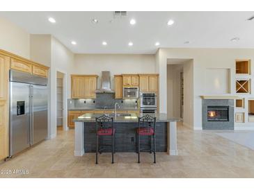 Bright kitchen features granite countertops, stainless steel appliances, and a fireplace creating a warm and inviting space at 41601 N River Bend Rd, Anthem, AZ 85086