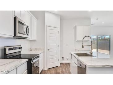 Bright kitchen with white cabinets, modern appliances and marble countertops at 5772 E Axle Ln, San Tan Valley, AZ 85140