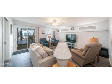 Bright living room features ceiling fan, neutral paint, and wood-look floors at 60 S Jacknife Dr, Apache Junction, AZ 85119