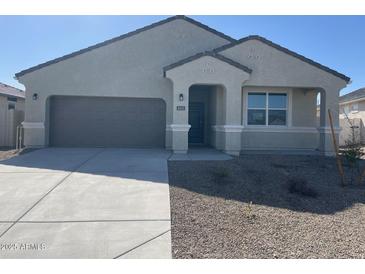 Charming single-story home featuring a neutral stucco exterior, a two-car garage, and a well-manicured, low-maintenance front yard at 631 W Freedom St, Florence, AZ 85132