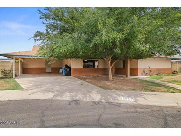 Charming single-story home featuring a covered carport and mature shade tree in the front yard at 6707 N 42Nd Ave, Phoenix, AZ 85019