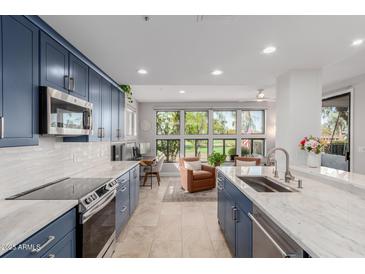 Modern kitchen with marble countertops, stainless steel appliances, and scenic views from large windows at 7700 E Gainey Ranch Rd # 127, Scottsdale, AZ 85258