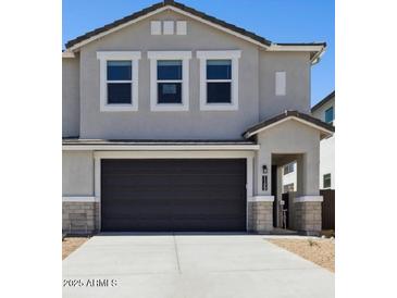Two-story home features a gray stucco exterior, dark brown garage door and modern architectural details at 1123 E Mcneil St, Phoenix, AZ 85042