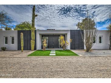 Stunning modern home with desert landscaping, black doors, and artificial grass at 12209 N 66Th St, Scottsdale, AZ 85254