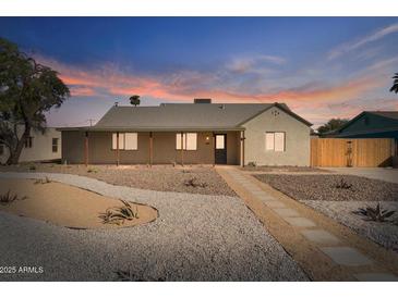 Charming single-story home featuring xeriscaping, a tile walkway and covered porch at 1642 E Turney Ave, Phoenix, AZ 85016