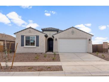 Charming single-story home featuring a two-car garage, stucco siding, and desert landscaping at 16735 W Whispering Wind Dr, Surprise, AZ 85387