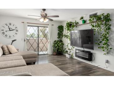 Cozy living room featuring a ceiling fan, diamond-paned window, and sleek hardwood floors at 1920 W Lindner W Ave # 277, Mesa, AZ 85202