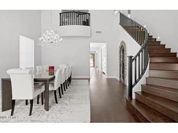Elegant dining area with high ceilings, wood floors, and a stunning chandelier at 280 W Wisteria Pl, Chandler, AZ 85248