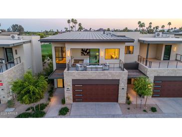 Modern two-story home with stone accents, a metal roof, and a balcony overlooking a golf course at 6331 E Phoenician Blvd # 6, Scottsdale, AZ 85251