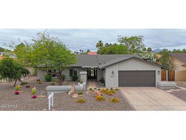 Charming single-story home boasts a desert landscaped yard, warm paint, and a two-car garage at 9621 N 83Rd Way, Scottsdale, AZ 85258