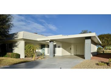 Charming single-story home featuring a covered carport, desert landscaping, and a welcoming facade at 10334 W Highwood Ln, Sun City, AZ 85373