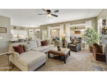 Inviting living room featuring a comfortable sectional sofa, stylish decor, and seamless access to the kitchen at 16008 S 13Th Way, Phoenix, AZ 85048