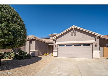 Charming single-story home with a well-maintained yard, desert landscaping, and a two-car garage at 17768 W Maui Ln, Surprise, AZ 85388