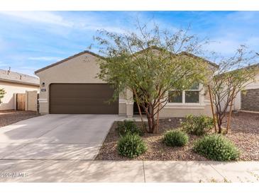 Charming single-story home with a well-manicured lawn and a two-car garage at 18621 W Hackamore Dr, Surprise, AZ 85387