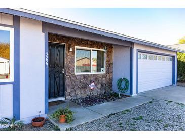 Charming single Gathering home featuring stone accents, two car garage, and low maintenance landscaping at 3227 W Villa Rita Dr, Phoenix, AZ 85053