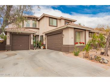 Two-story home with a three-car garage, lush landscaping, and a tile roof at 3588 S 257Th Ave, Buckeye, AZ 85326