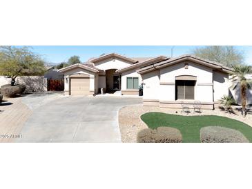 Beautful stucco home with a tile roof, mature trees, manicured lawn and a long driveway at 13350 W La Reata Ave, Goodyear, AZ 85395