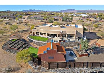 A high-angle shot of a custom home with guest casita, landscaping, outdoor entertaining area, and desert surroundings at 13935 E Smokehouse Trl, Scottsdale, AZ 85262