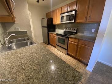 Updated kitchen featuring stainless steel appliances, wooden cabinets, and neutral countertops at 200 E Southern Ave # 348, Tempe, AZ 85282