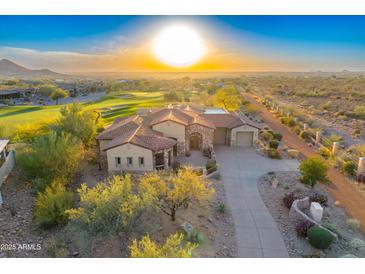 Stunning sunset aerial view of a luxury home with red tile roof and lush desert landscaping at 2430 S Geronimo Head Trl, Gold Canyon, AZ 85118