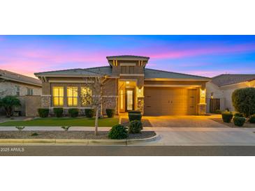 Charming single-story home with a manicured front yard, stone accents, and a two-car garage at 4462 S Frequency Dr, Mesa, AZ 85212