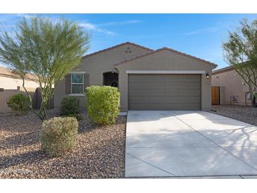 Charming single-story home featuring a well-manicured front yard with desert landscaping and a two-car garage at 4595 W Stonecrop Dr, San Tan Valley, AZ 85144